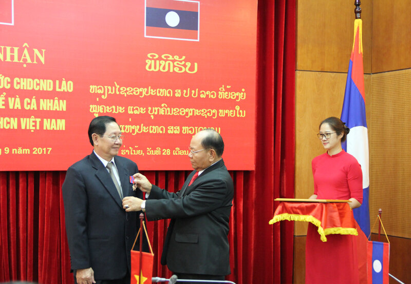 Đồng chí Khamman Sounvileuth, Ủy viên Trung ương Đảng Nhân dân Cách mạng Lào, Bộ trưởng Bộ Nội vụ Lào trao Huân chương Itxala hạng II cho đồng chí Lê Vĩnh Tân, Bộ trưởng Bộ Nội vụ nước CHXHCN Việt Nam